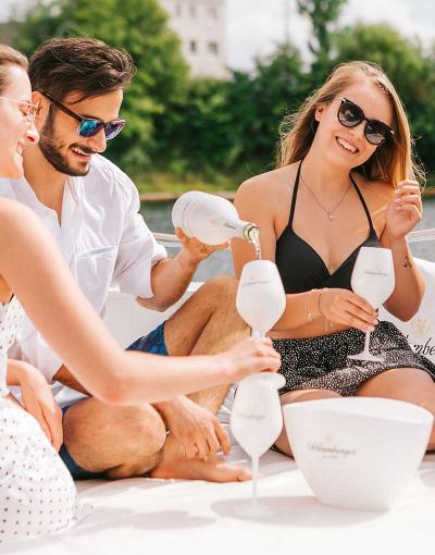 Drei junge Leute genießen Schlumberger auf einem Boot